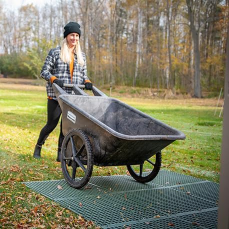 GEOBIN - Woman pushing wheelbarrow across green GEORUNNER surface panels on grass in autumn outdoor setting